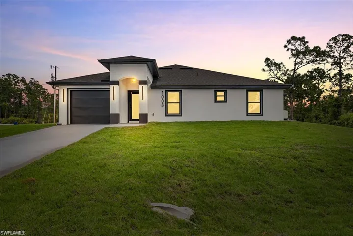 Contemporary single-story residence featuring a two-tone exterior, dark shingle roof, and a two-car garage with a modern door