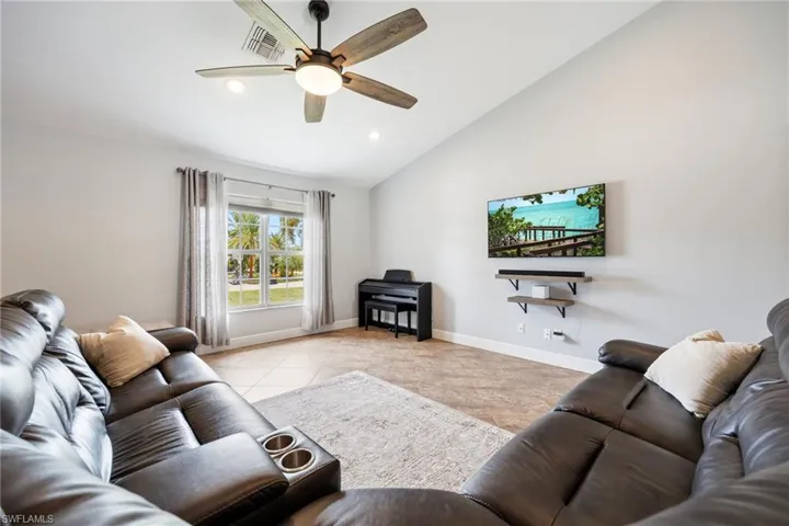 Spacious living area featuring vaulted ceilings, tile flooring, and recessed lighting