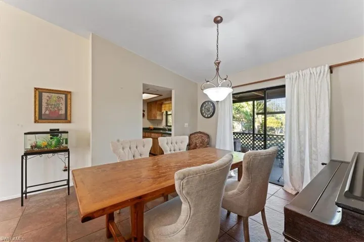 Dining area with vaulted ceiling and light tile patterned floors