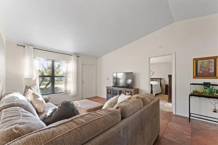 Living area with lofted ceiling and tile patterned floors