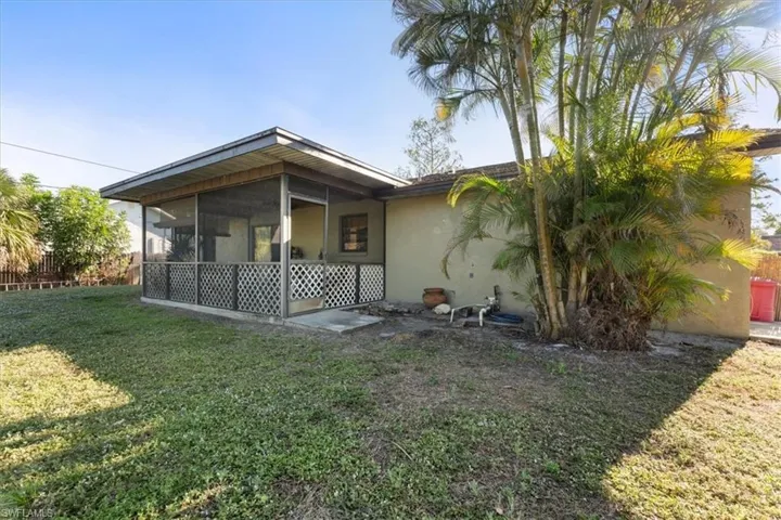 Rear view of house featuring a yard, and stucco siding