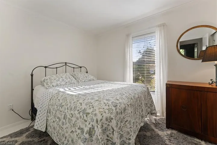 Carpeted bedroom with ornamental molding