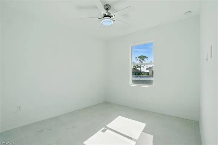 Unfurnished room featuring ceiling fan and a smoke detector