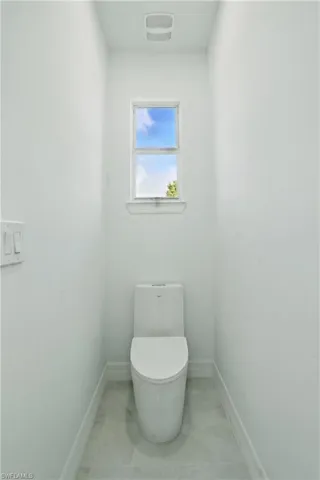 Bathroom featuring toilet and baseboards