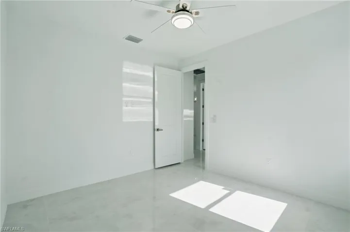 Unfurnished room with a ceiling fan and baseboards