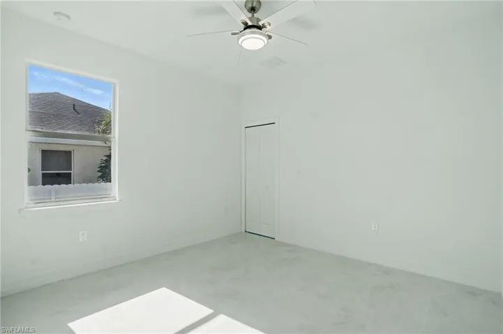 Unfurnished room with ceiling fan and baseboards