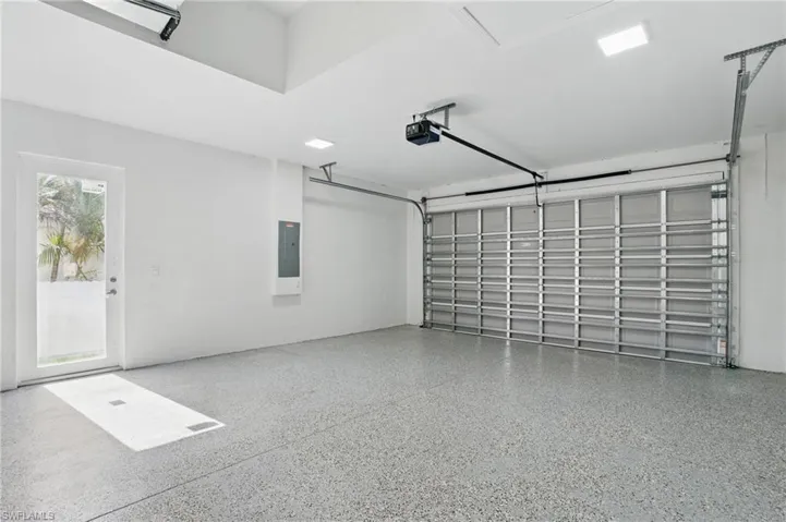 Garage featuring a garage door opener and electric panel