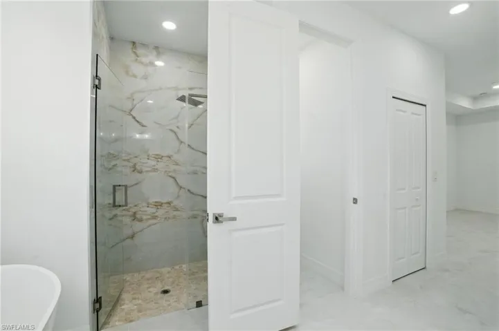 Bathroom featuring a marble finish shower, a freestanding tub, recessed lighting, and marble finish flooring