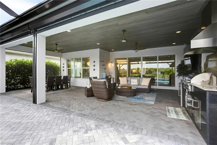 View of patio featuring an outdoor hangout area, area for grilling, glass enclosure, outdoor dining space, and a ceiling fan
