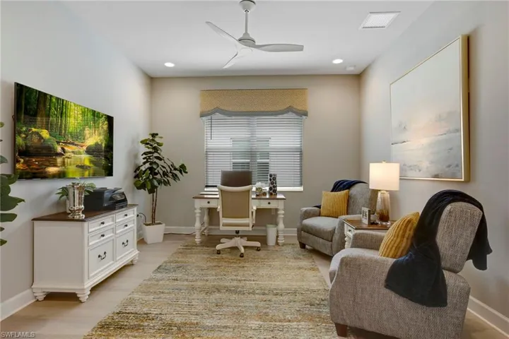 Office featuring baseboards, visible vents, light wood-style floors, and ceiling fan