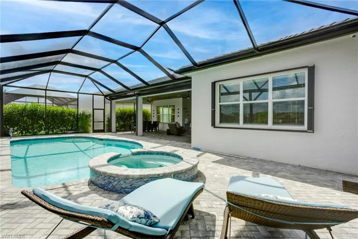 View of swimming pool featuring a patio and a pool with connected hot tub