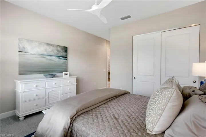 Bedroom featuring carpet flooring, baseboards, ceiling fan, visible vents, and a closet