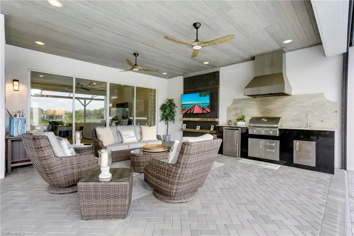 View of patio featuring outdoor lounge area, an outdoor kitchen, grilling area, and a ceiling fan