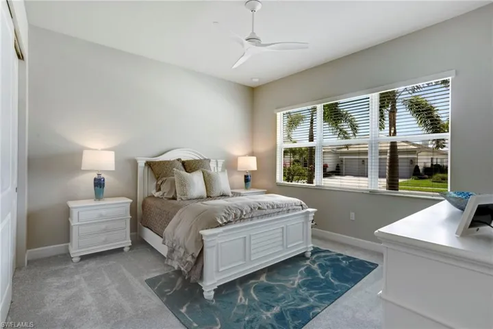 Bedroom with a ceiling fan, baseboards, and light colored carpet
