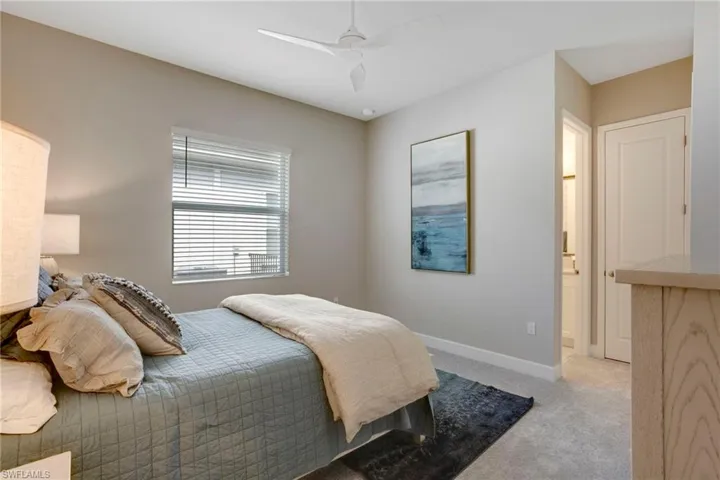 Bedroom with a ceiling fan, baseboards, and light colored carpet