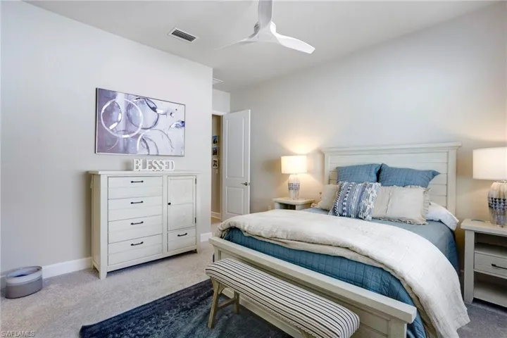 Bedroom featuring carpet flooring, baseboards, ceiling fan, and visible vents