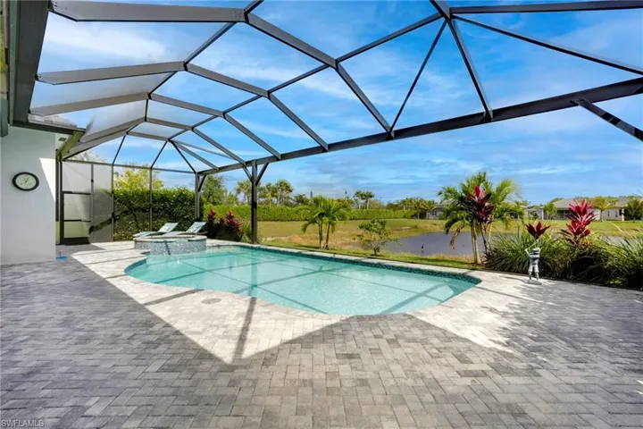 View of pool featuring a pool with connected hot tub, a lanai, and a patio area
