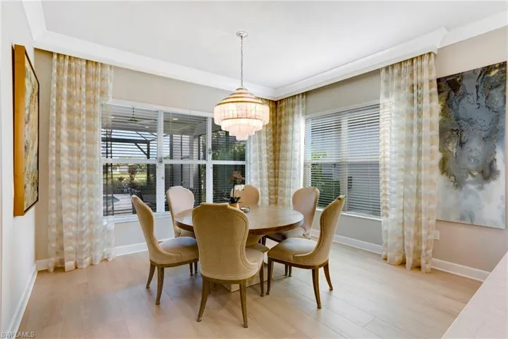 Dining room featuring baseboards, light wood-style floors, and a chandelier