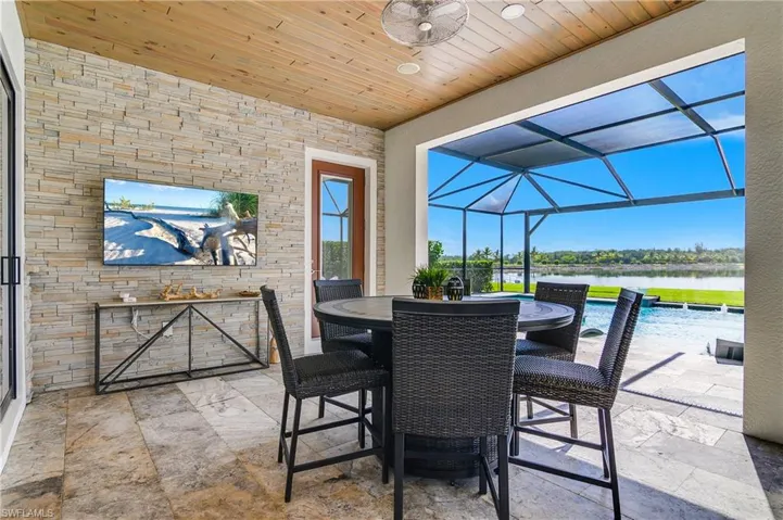 Outdoor lanai features stack stone which matches the front of the home and tongue and groove wood accent ceiling.