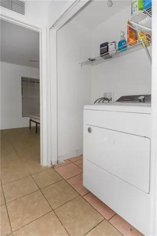 Laundry area featuring washer / dryer and light tile patterned floors