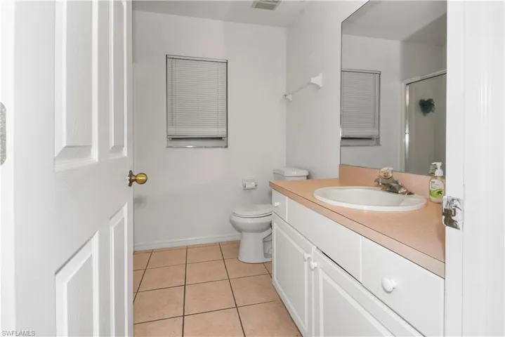 Full bath featuring light tile patterned flooring, vanity, and a stall shower