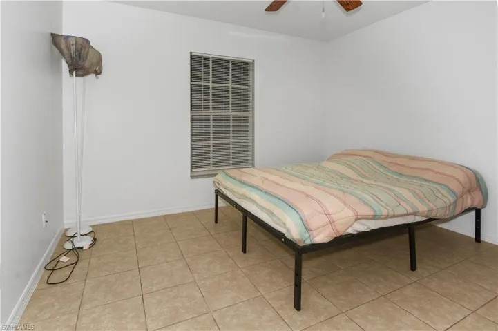 Bedroom with ceiling fan and light tile patterned floors
