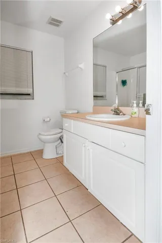 Bathroom with vanity, a stall shower, and light tile patterned flooring