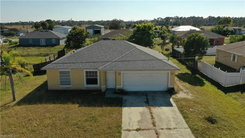 Single story home with driveway, a residential view, roof with shingles, a garage, and stucco siding