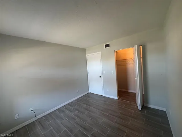 Unfurnished bedroom with a spacious closet and a closet