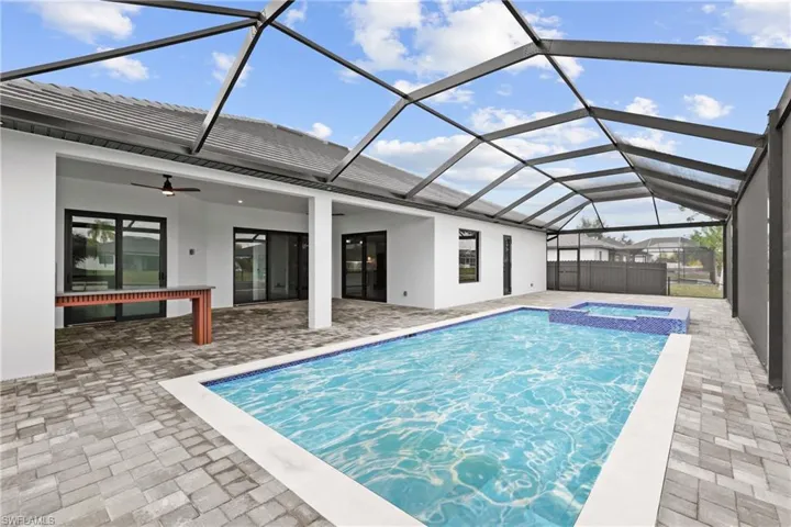 View of pool featuring an in ground hot tub, ceiling fan, glass enclosure, and a patio