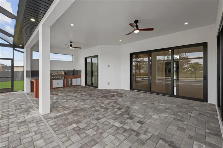 View of patio featuring exterior kitchen, area for grilling, sink, and ceiling fan
