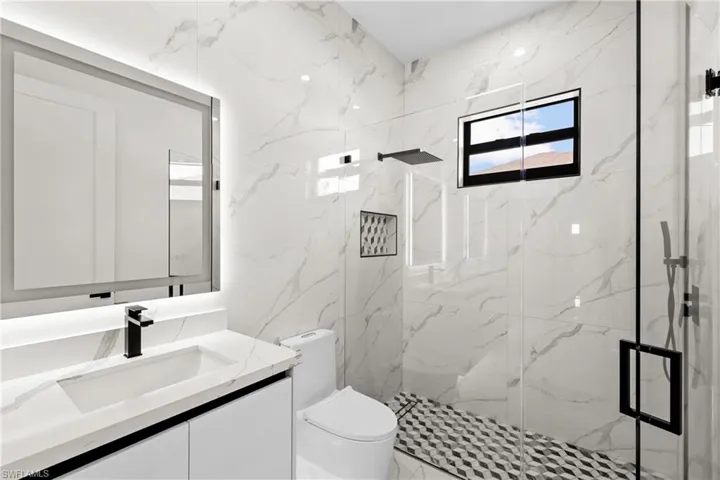 Bathroom with vanity, tiled shower, and toilet
