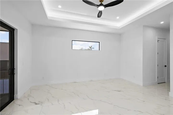 Unfurnished room featuring a raised ceiling and ceiling fan