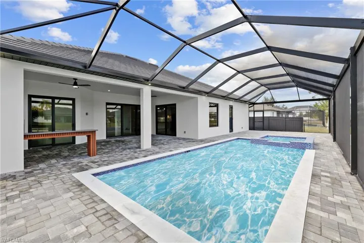 View of swimming pool with an in ground hot tub, a lanai, ceiling fan, and a patio area