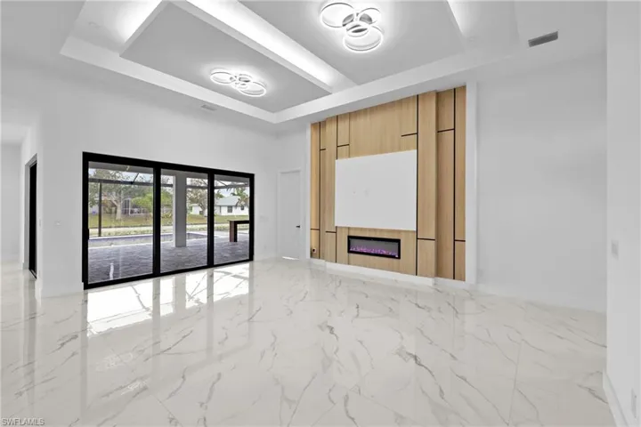 Unfurnished living room with a towering ceiling and a raised ceiling