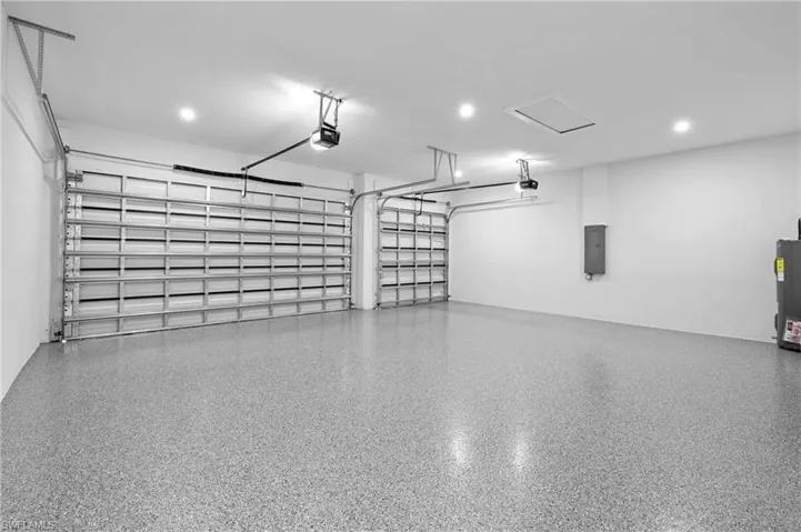 Garage featuring a garage door opener and electric panel