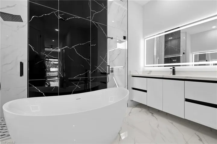 Bathroom featuring vanity and separate shower and tub