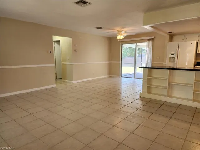 Standing at front door looking through living area towards dining and patio door