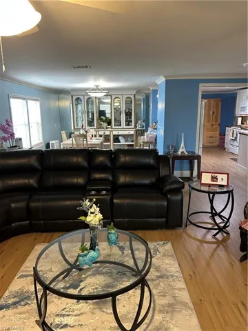 Living area featuring ornamental molding and light wood finished floors