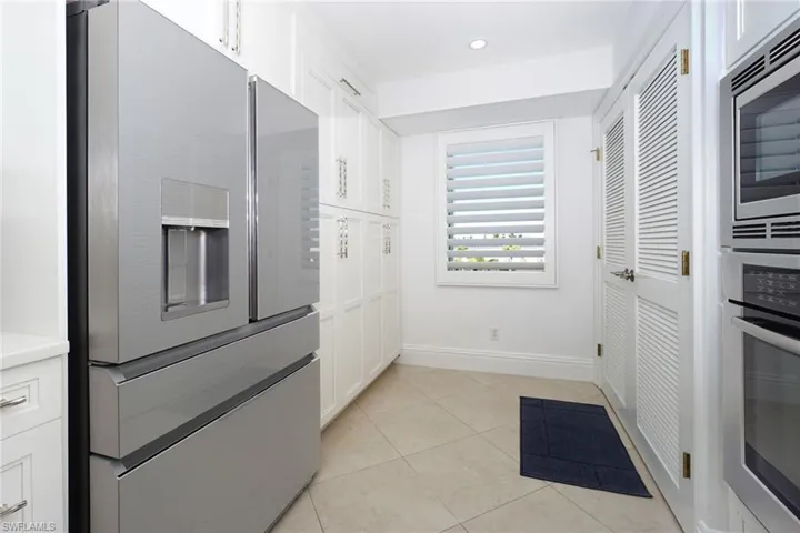 Kitchen featuring white cabinetry, stainless steel appliances, light tile patterned floors, light countertops, and recessed lighting