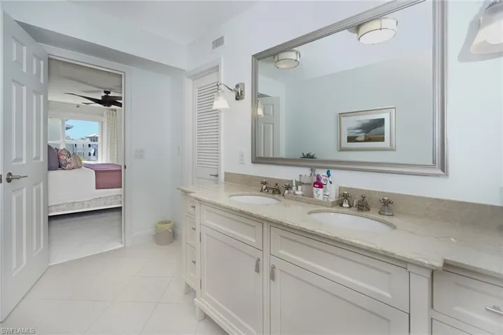 Bathroom with double vanity, ensuite bath, ceiling fan, and light tile patterned floors