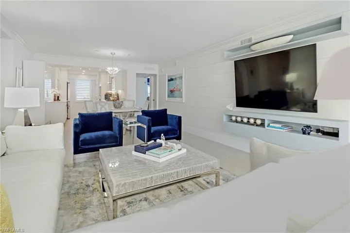 Living room with ornamental molding and a chandelier