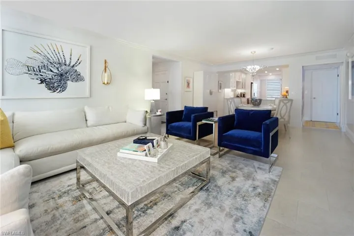 Living area featuring ornamental molding and a chandelier