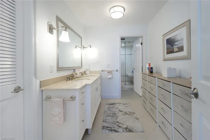 Full bath featuring vanity, a stall shower, and light tile patterned floors