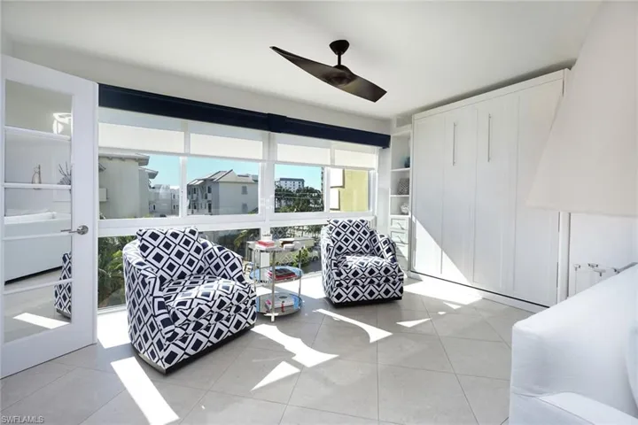 Living area featuring light tile patterned flooring and ceiling fan