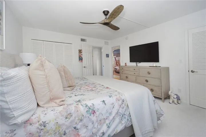 Bedroom with ceiling fan, carpet flooring, and a closet