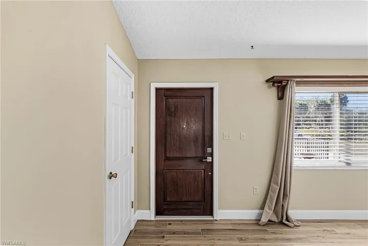 Entrance foyer with light wood-type flooring and a textured ceiling