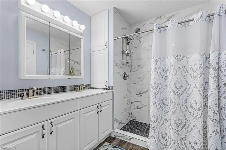 Bathroom with a shower stall and double vanity