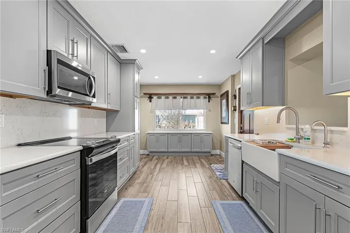 Kitchen featuring gray cabinetry, stainless steel appliances, light wood-style floors, and recessed lighting