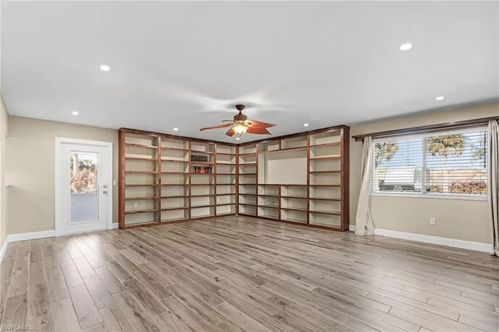 Unfurnished living room with healthy amount of natural light, a ceiling fan, light wood-style floors, and recessed lighting